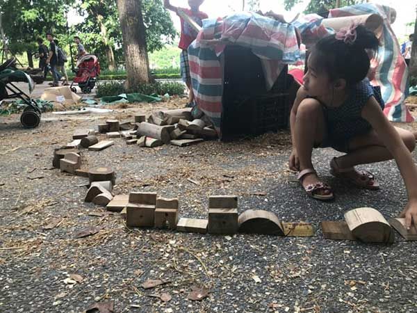 Des enfants construisent avec des planches et des cageots dans la cour