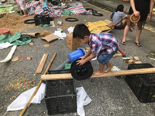 Un enfant transporte du matériel de réemploi pour construire