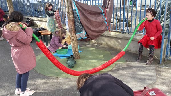 Des enfants déroulent un long tube souple à plusieurs